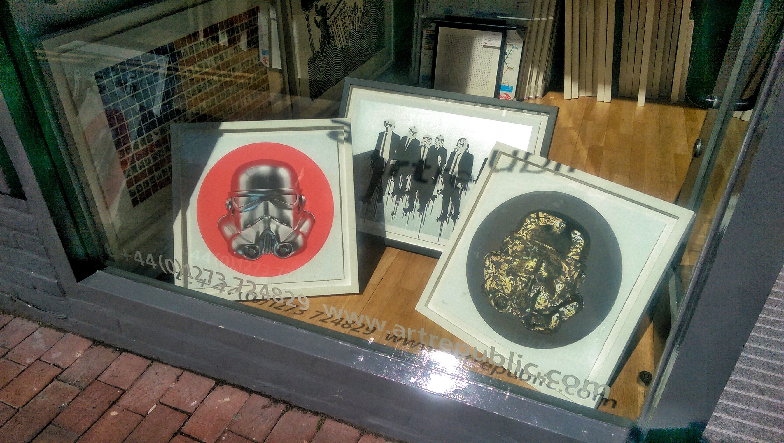 Three framed trooper prints catching sun in the artrepublic window